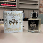 Tajmax Oud 777 perfume bottle and packaging on a kitchen counter.