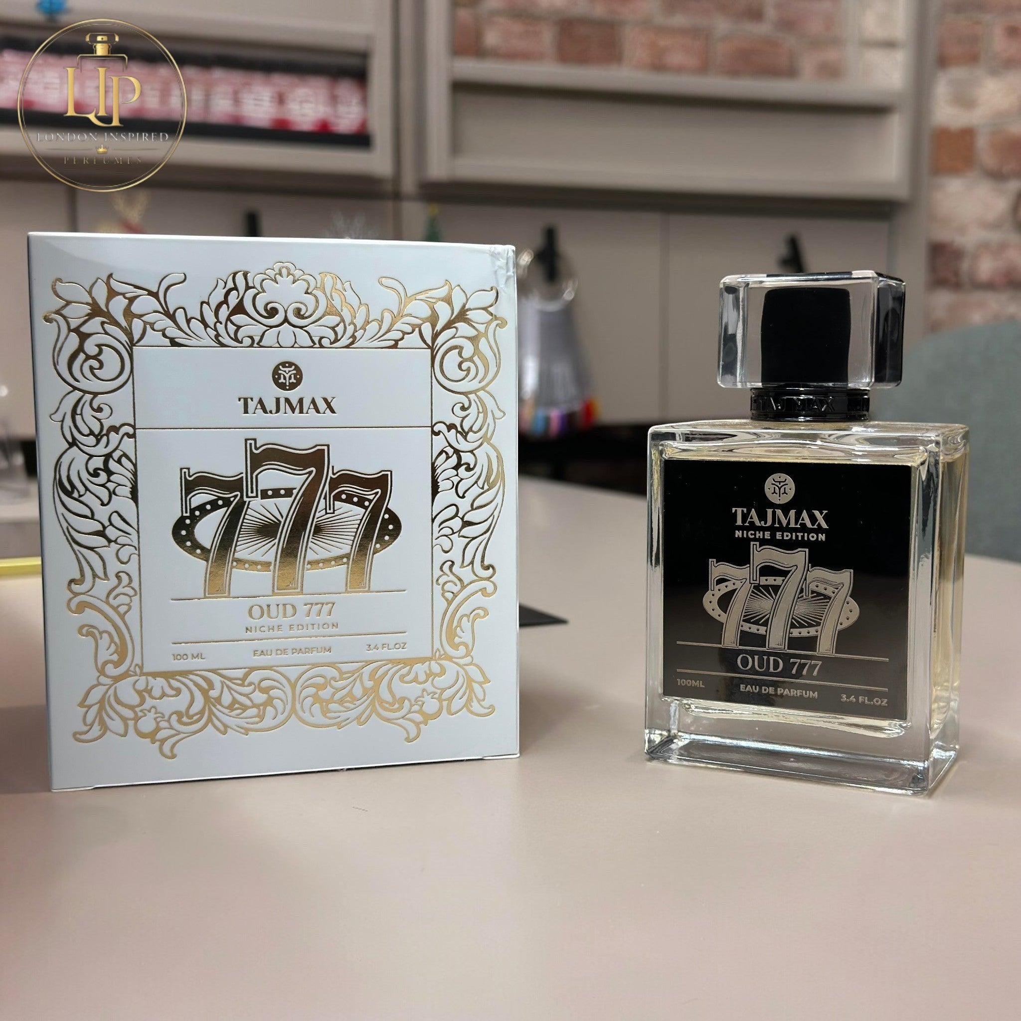 Tajmax Oud 777 perfume bottle and packaging on a table