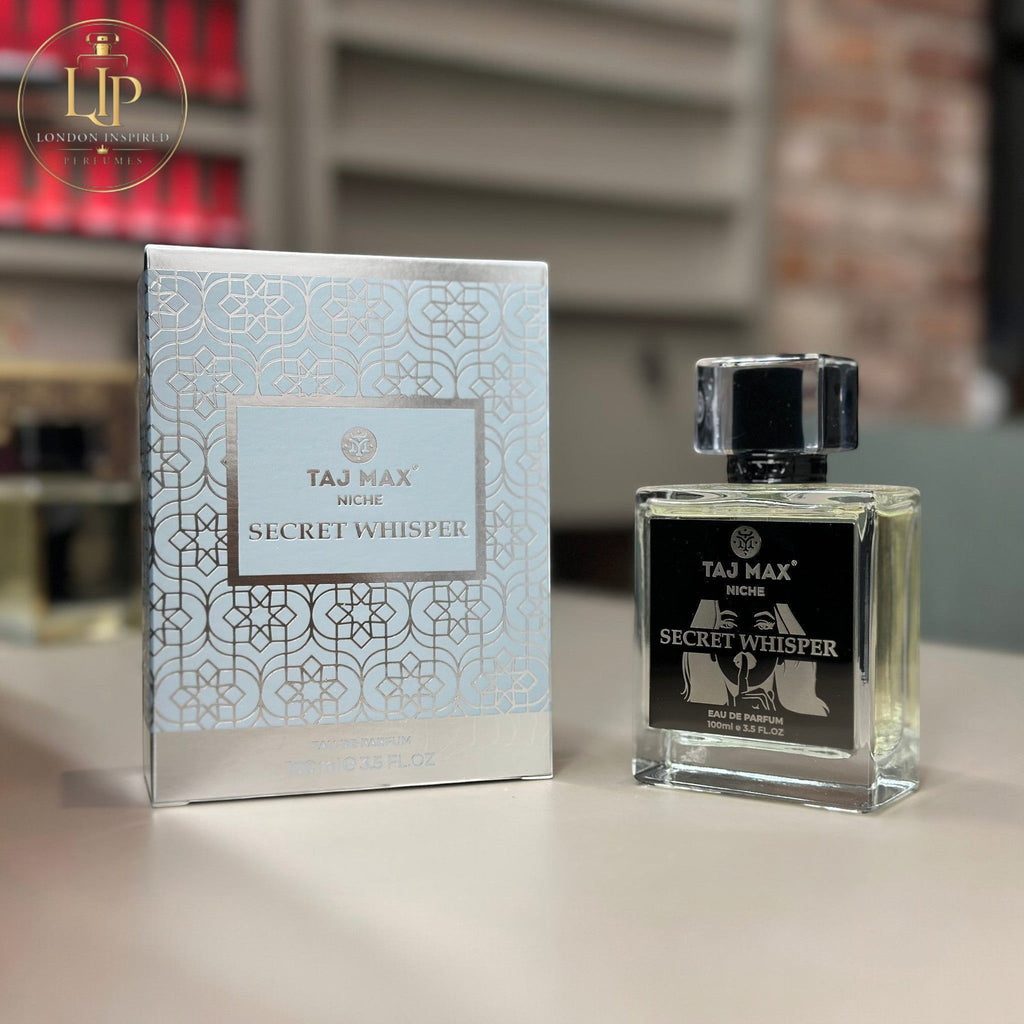 Perfume bottle and packaging of Taj Max Secret Whisper on a table.